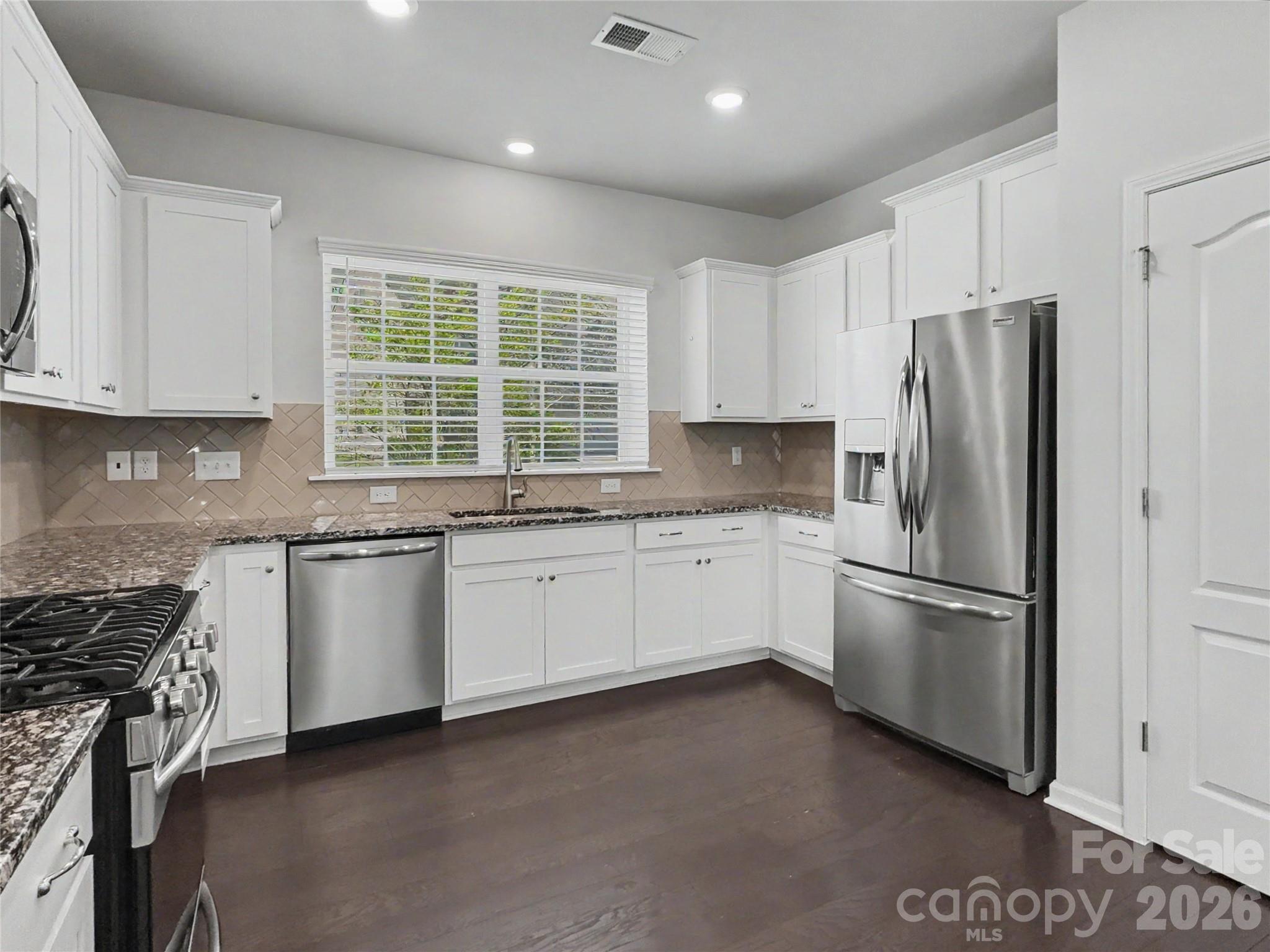 16835 Cozy Cove Road Charlotte, NC 28278 - Photo 6 of 32 a kitchen with granite countertop white cabinets and stainless steel appliances