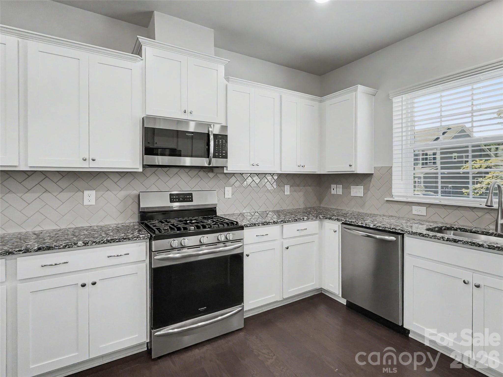 16835 Cozy Cove Road Charlotte, NC 28278 - Photo 8 of 32 a kitchen with granite countertop white cabinets and stainless steel appliances