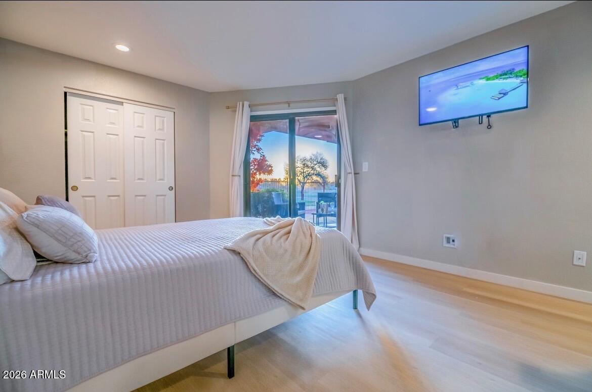 4303 East Cactus Road, Unit 128 Phoenix, AZ 85032 - Photo 19 of 39 a bedroom with a bed and wooden floor