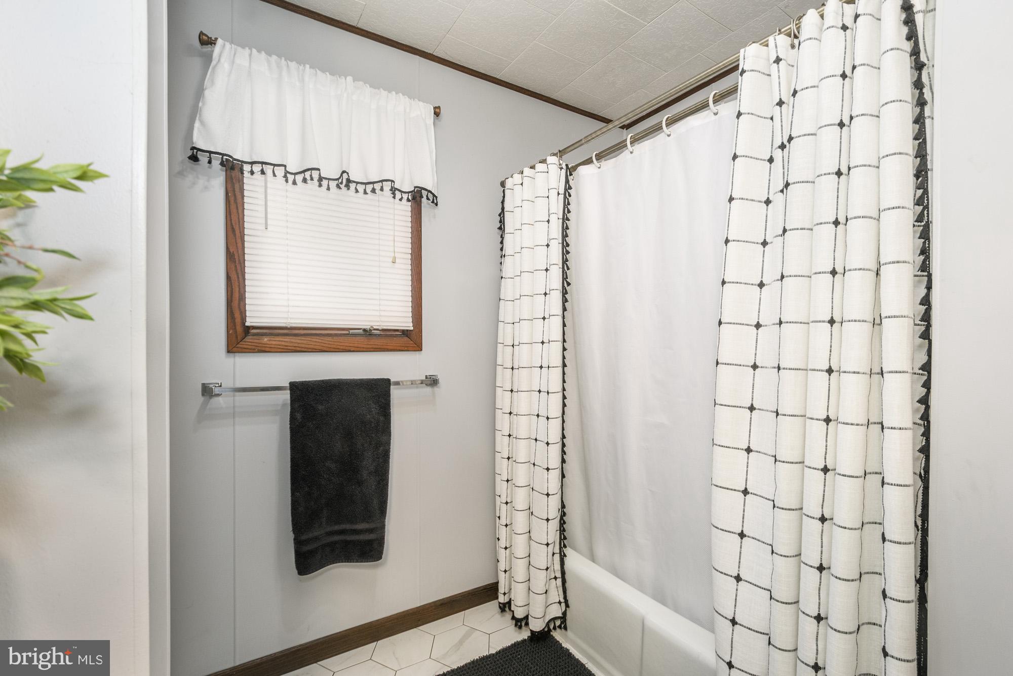 18 Frederick Circle Swanton, MD 21561 - Photo 30 of 64 a bathroom with a shower curtain and a window
