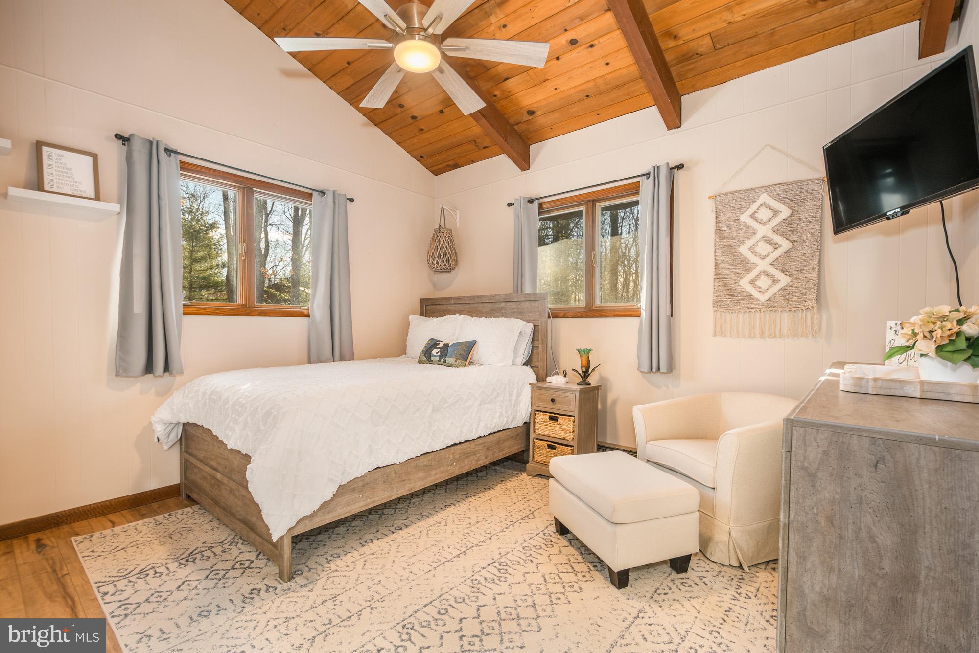 18 Frederick Circle Swanton, MD 21561 - Photo 34 of 63 a bedroom with a large bed and a flat screen tv