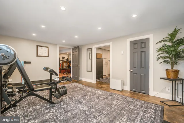 a view of a swimming pool with lawn chairs and large trees