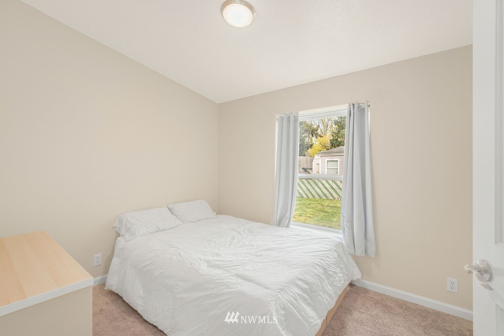 15400 Southeast 155th Place, Unit 7 Renton, WA 98058 - Photo 19 of 26 a bedroom with a bed and a window