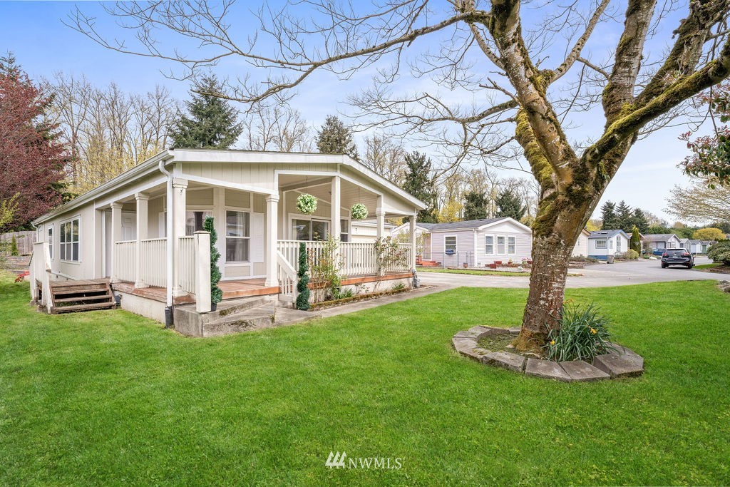 15400 Southeast 155th Place, Unit 7 Renton, WA 98058 - Photo 4 of 26 a front view of a house with a garden and trees