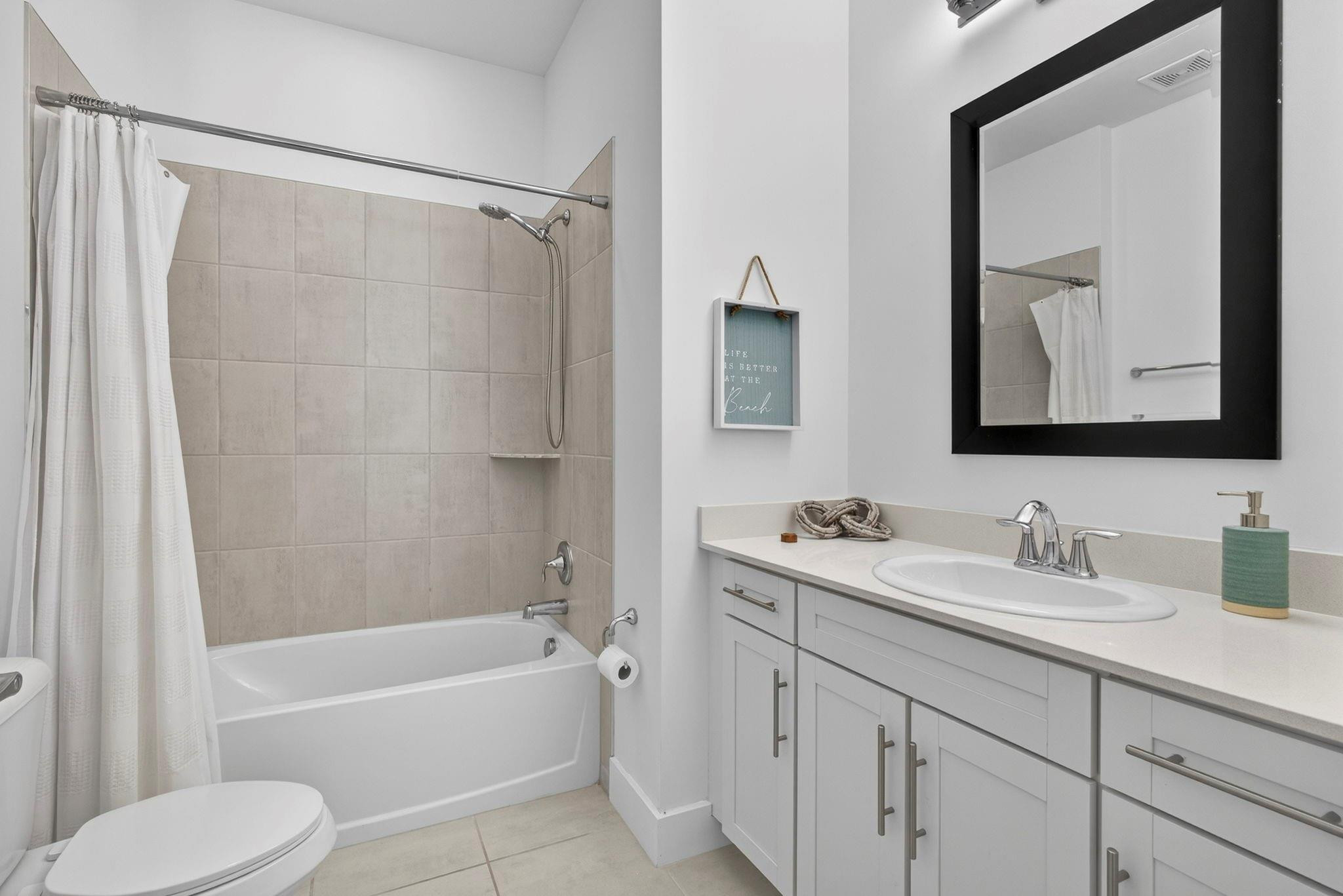 16587 Cove Road The Acreage, FL 33470 - Photo 13 of 69 a bathroom with a toilet a sink a mirror a bathtub and shower