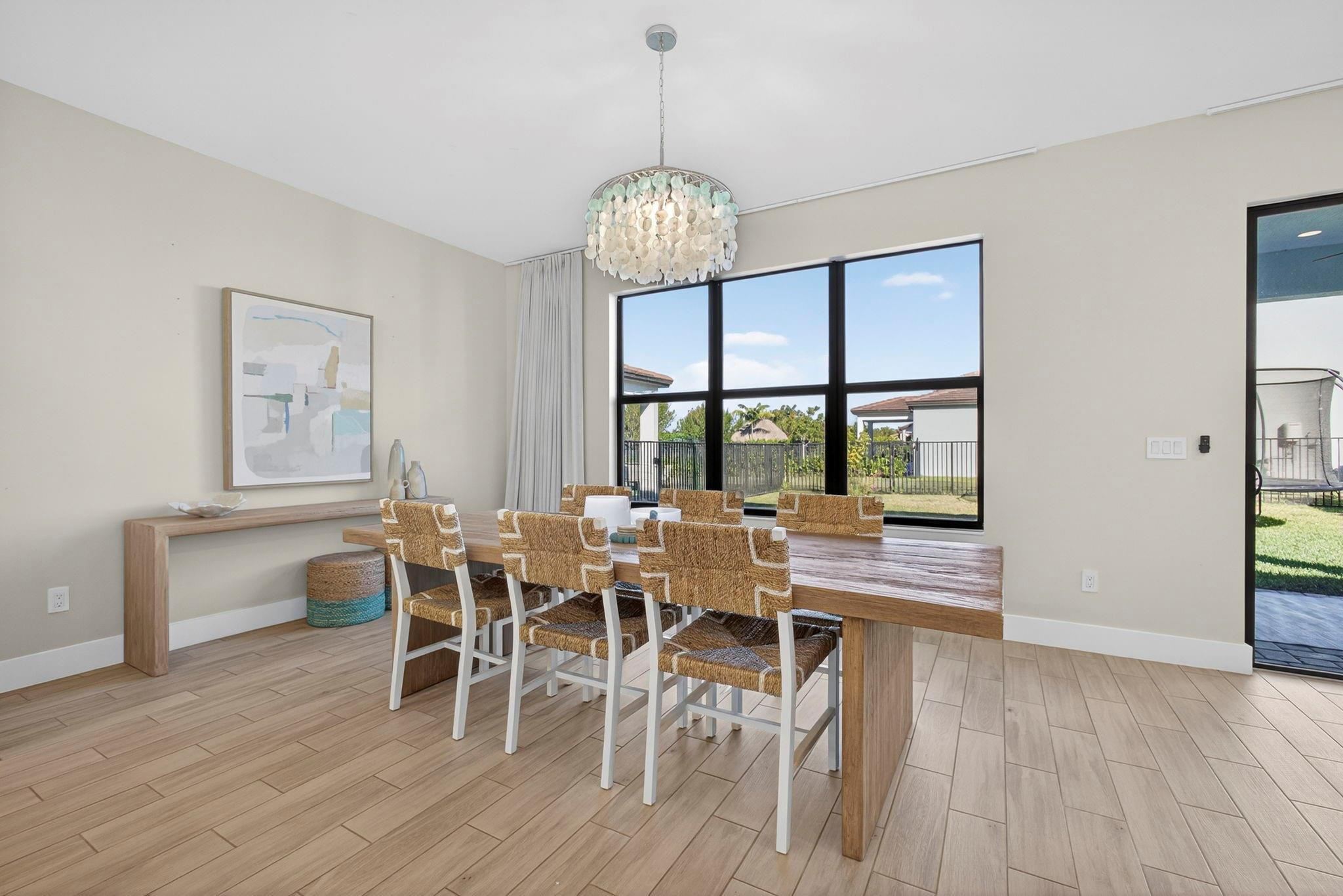 16587 Cove Road The Acreage, FL 33470 - Photo 29 of 69 a dining room with furniture a chandelier and wooden floor