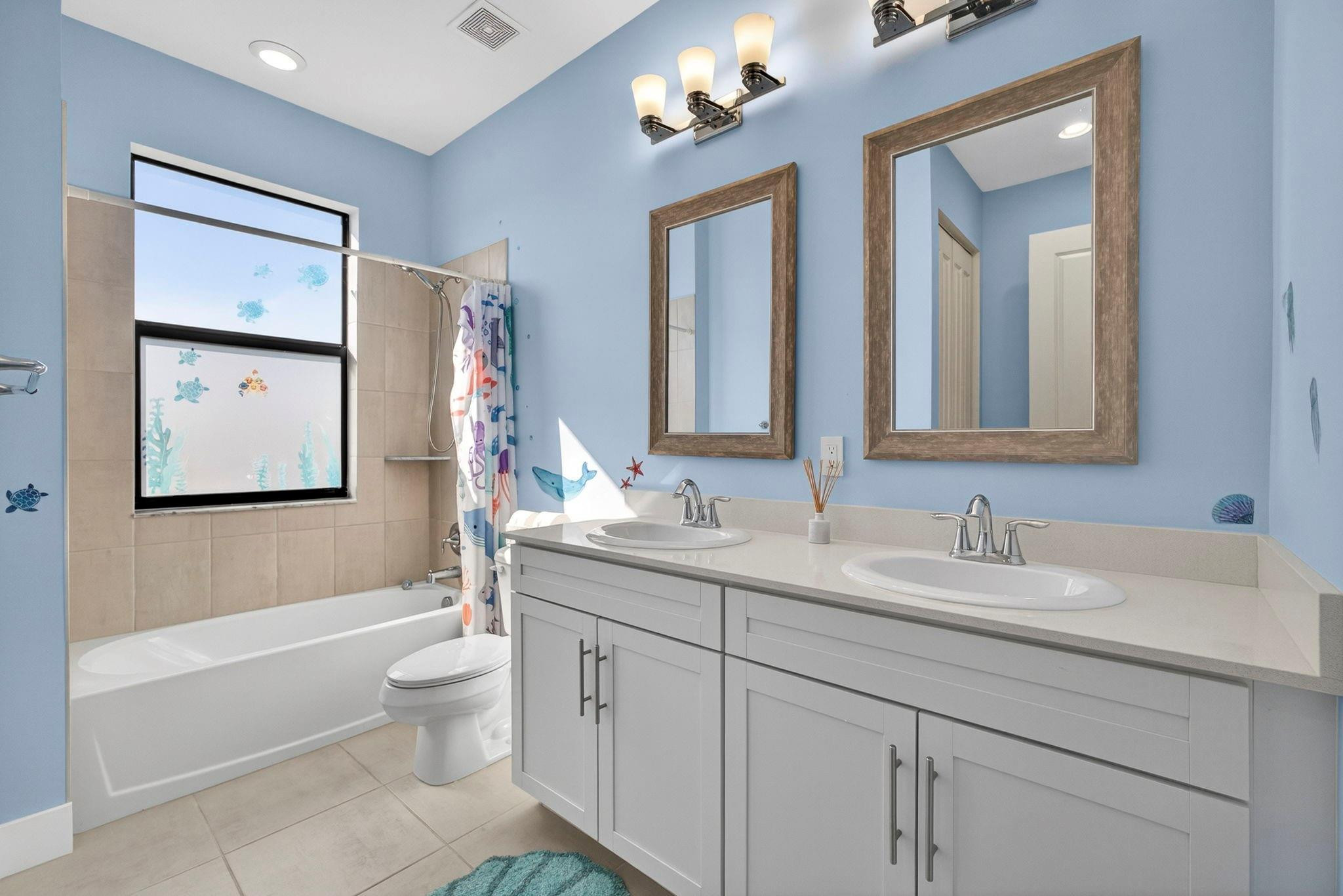 16587 Cove Road The Acreage, FL 33470 - Photo 41 of 69 a bathroom with double vanity sinks a toilet a mirror and a tub