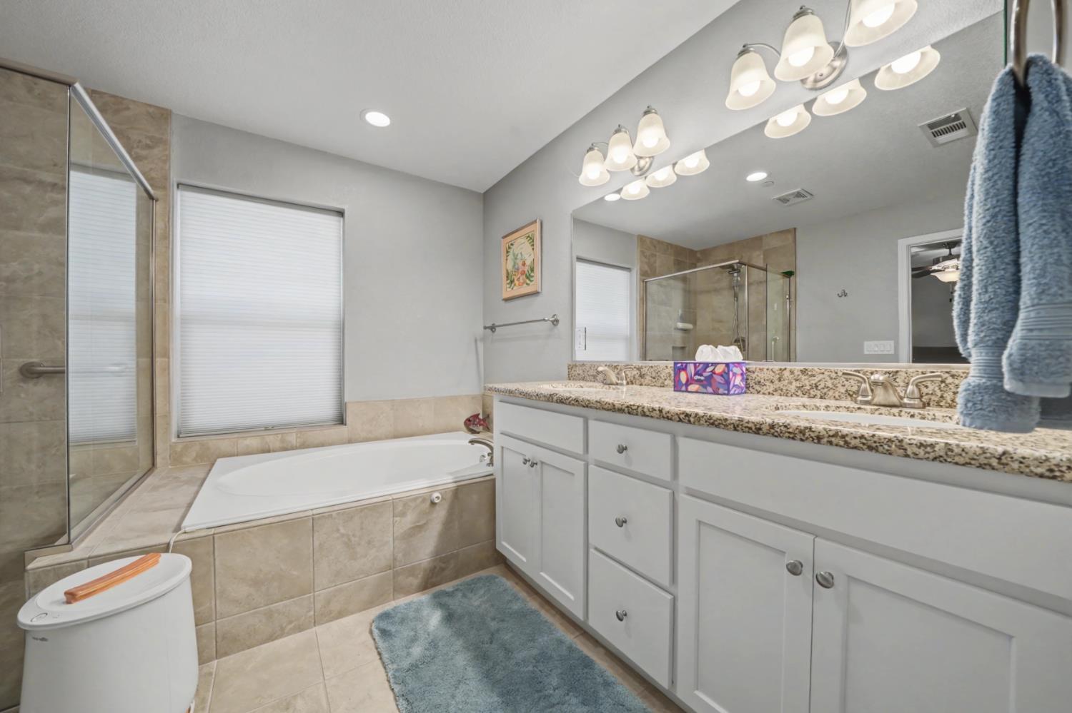 143 Emerald Lane Jackson, CA 95642 - Photo 36 of 53 a bathroom with a granite countertop sink a large mirror and a bathtub