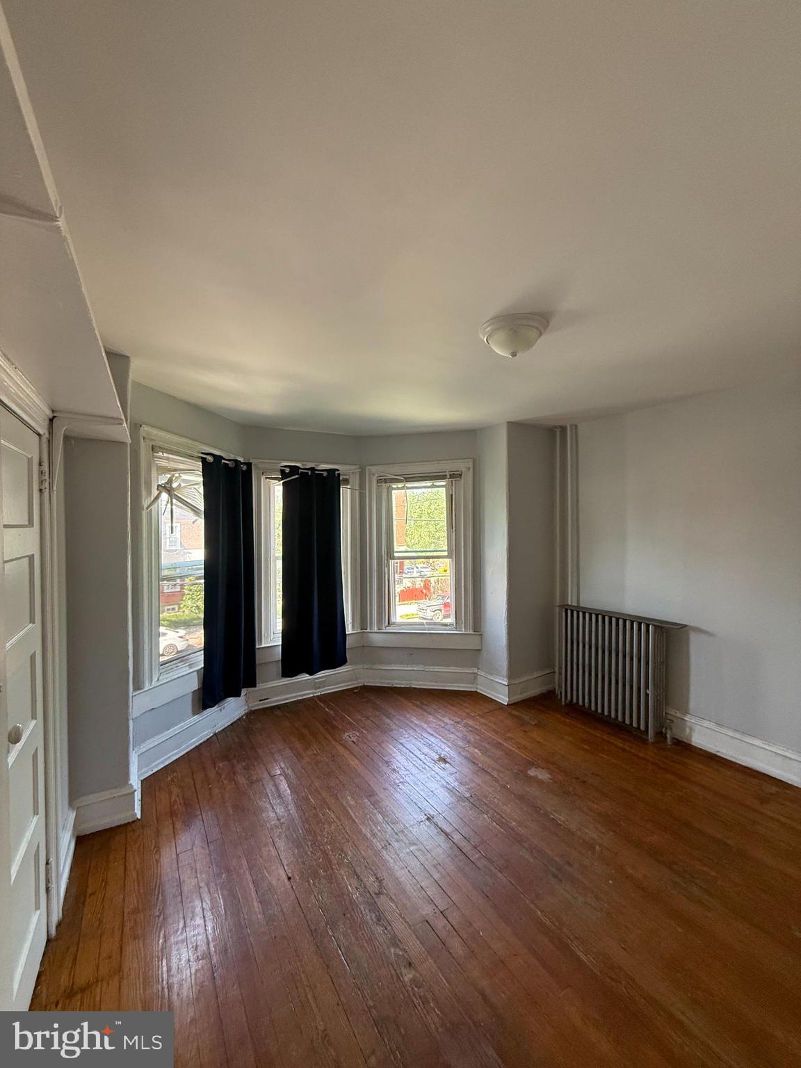 5336 Vine Street, Unit 2F Philadelphia, PA 19139 - Photo 2 of 7 an empty room with wooden floor and windows