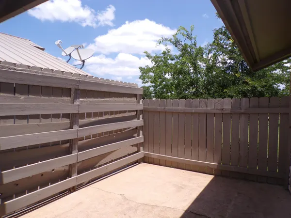 a view of backyard with wooden fence