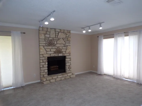 an empty room with a fireplace and window
