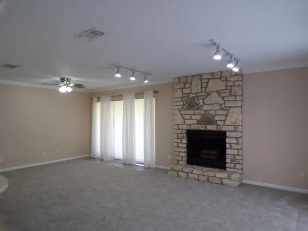 an empty room with fireplace and fan