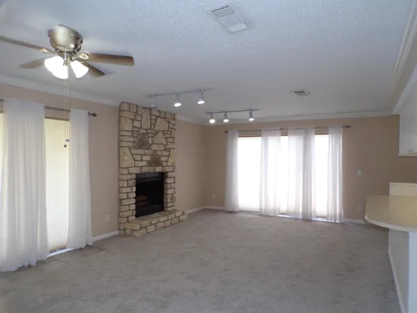 a view of an empty room with window and fire place
