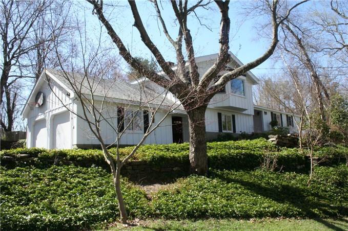 a large tree in the garden in front of a house