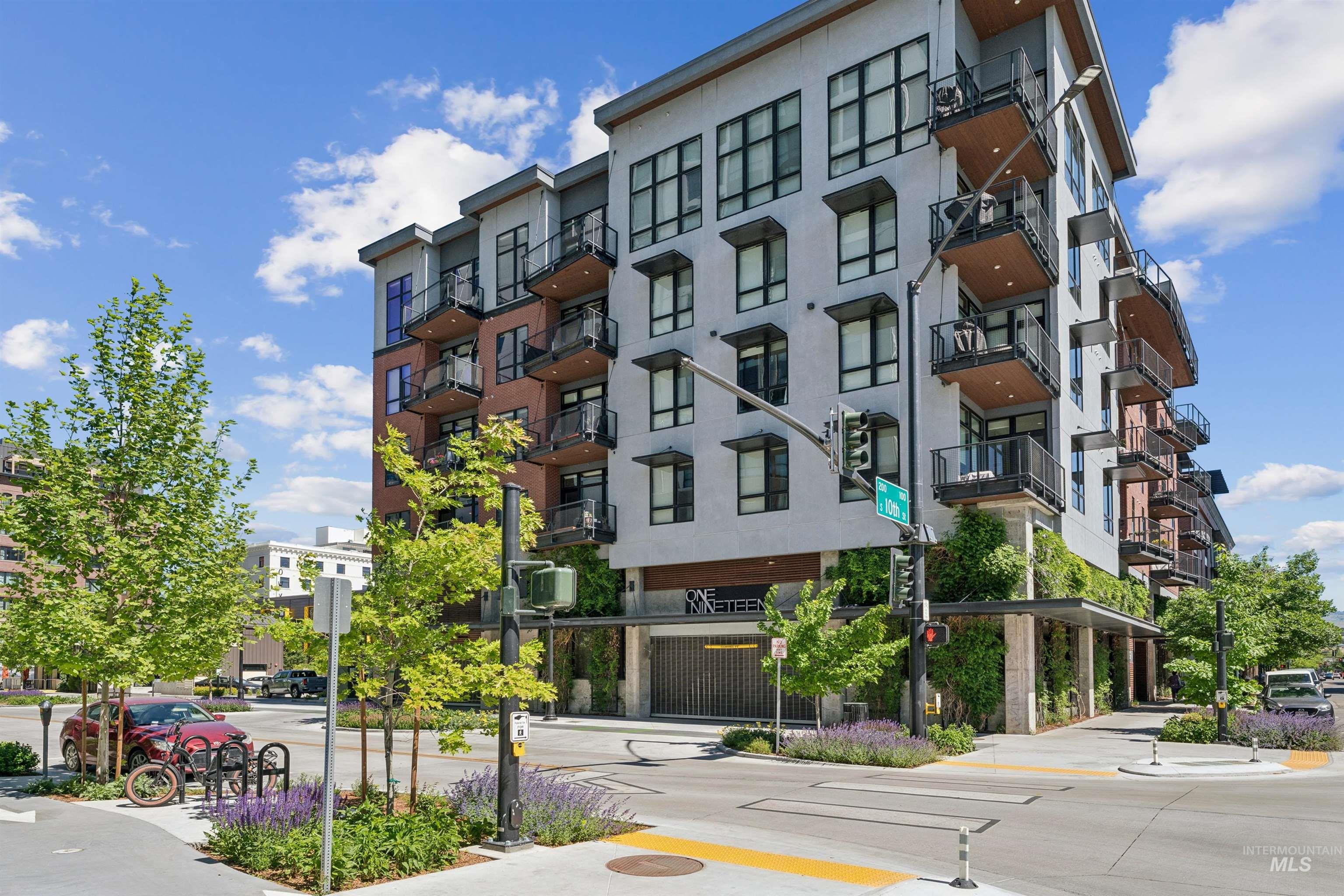 Modern multi-story building featuring a facade with mixed materials including light-toned siding and brick accents