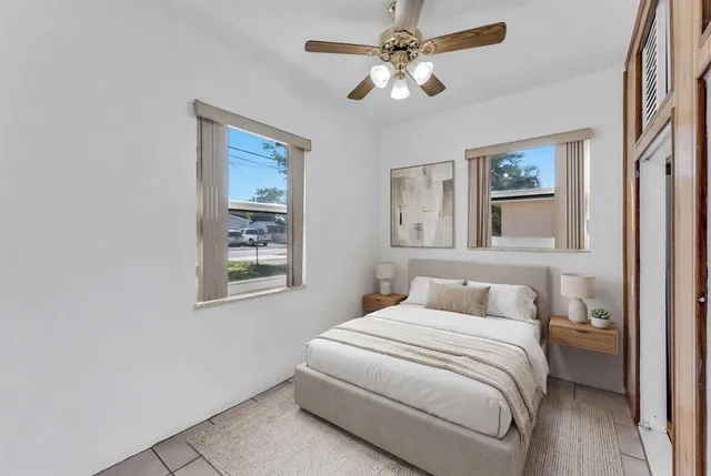 an empty room with windows and fan