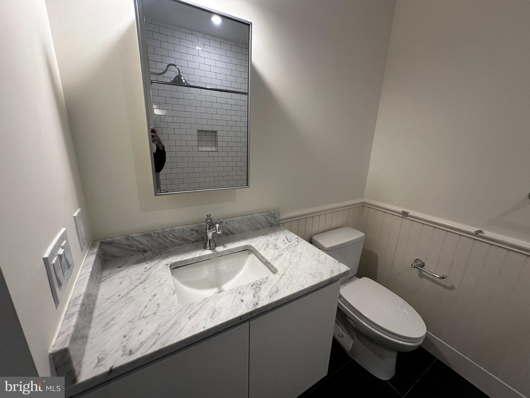 1801 North Howard Street, Unit 208 Philadelphia, PA 19122 - Photo 14 of 17 a bathroom with a granite countertop sink a toilet and a mirror