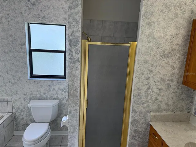 a bathroom with a granite countertop sink and a toilet