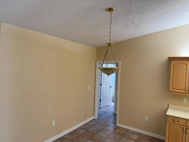a view of a livingroom with a chandelier fan and a window