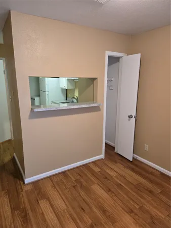 an empty room with wooden floor and closet
