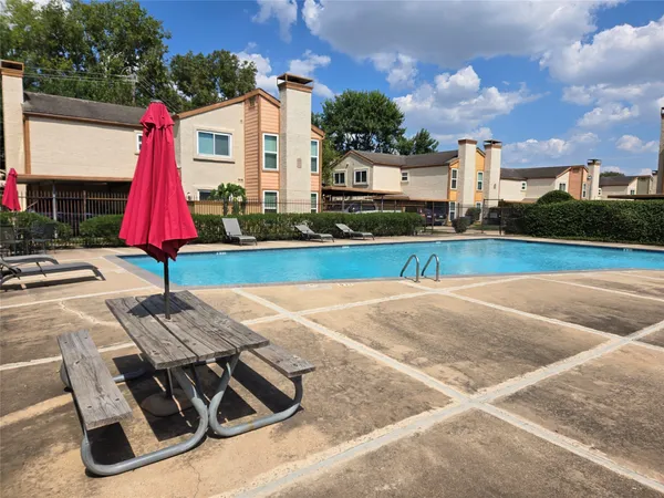 a view of backyard with swimming pool and seating