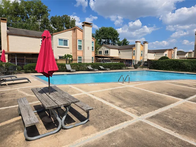 a view of backyard with swimming pool and seating