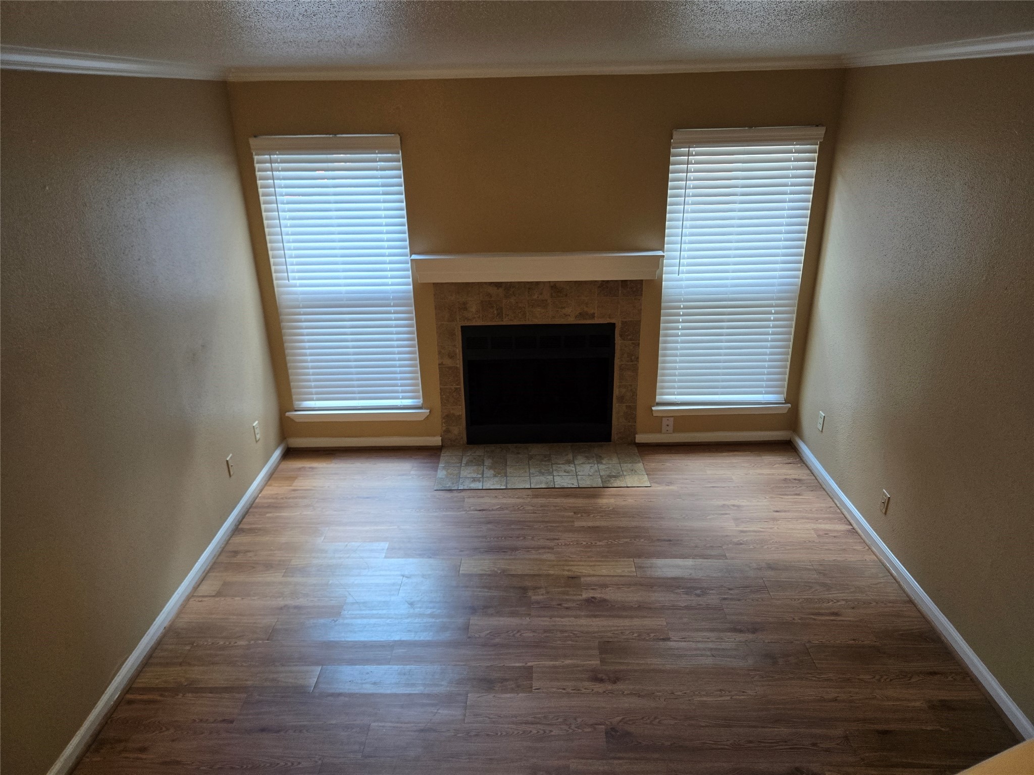 13210 Old Richmond Road, Unit A Houston, TX 77083 - Photo 9 of 21 an empty room with wooden floor fireplace and windows