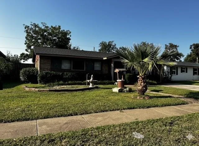 a front view of a house with garden and trees