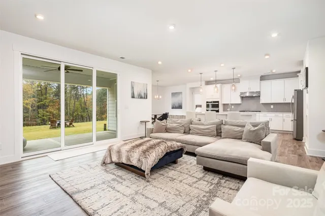 a large white kitchen with lots of counter space dining table and stainless steel appliances