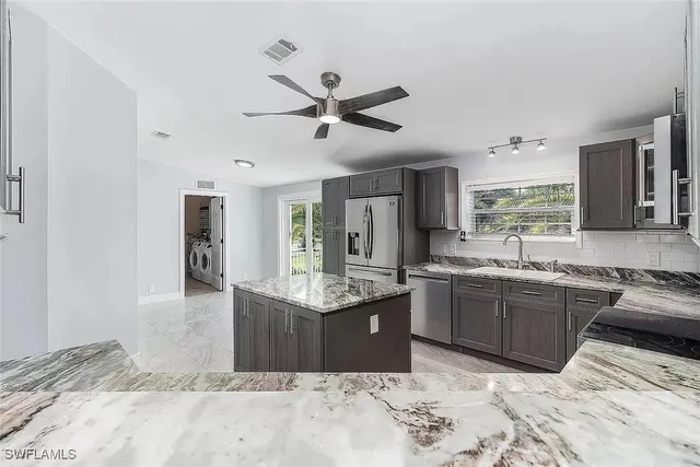 a kitchen with stainless steel appliances granite countertop a sink stove and refrigerator