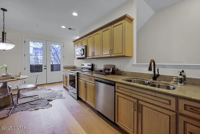 a kitchen with stainless steel appliances granite countertop a sink stove and cabinets