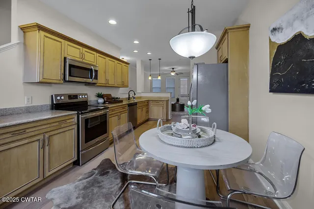 a kitchen with stainless steel appliances a dining table and chairs