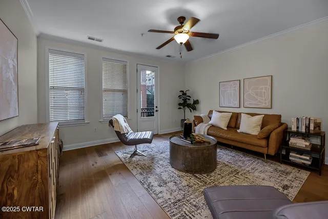 a living room with furniture wooden floor and a window