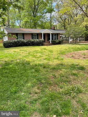 a front view of a house with yard and trees