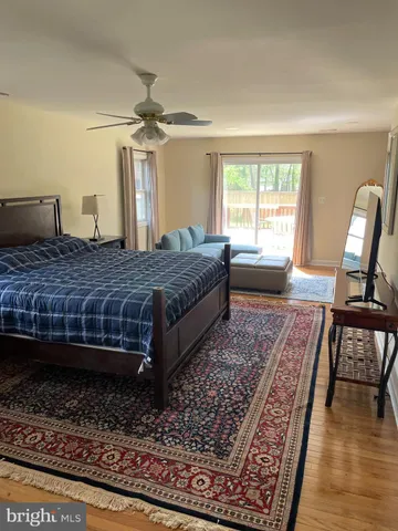 a bedroom with a large bed and wooden floor
