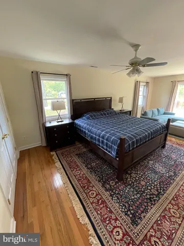 a bedroom with a bed rug and wooden floor