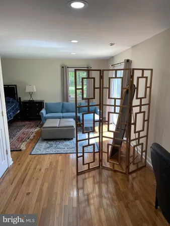 a living room with furniture and a wooden floor