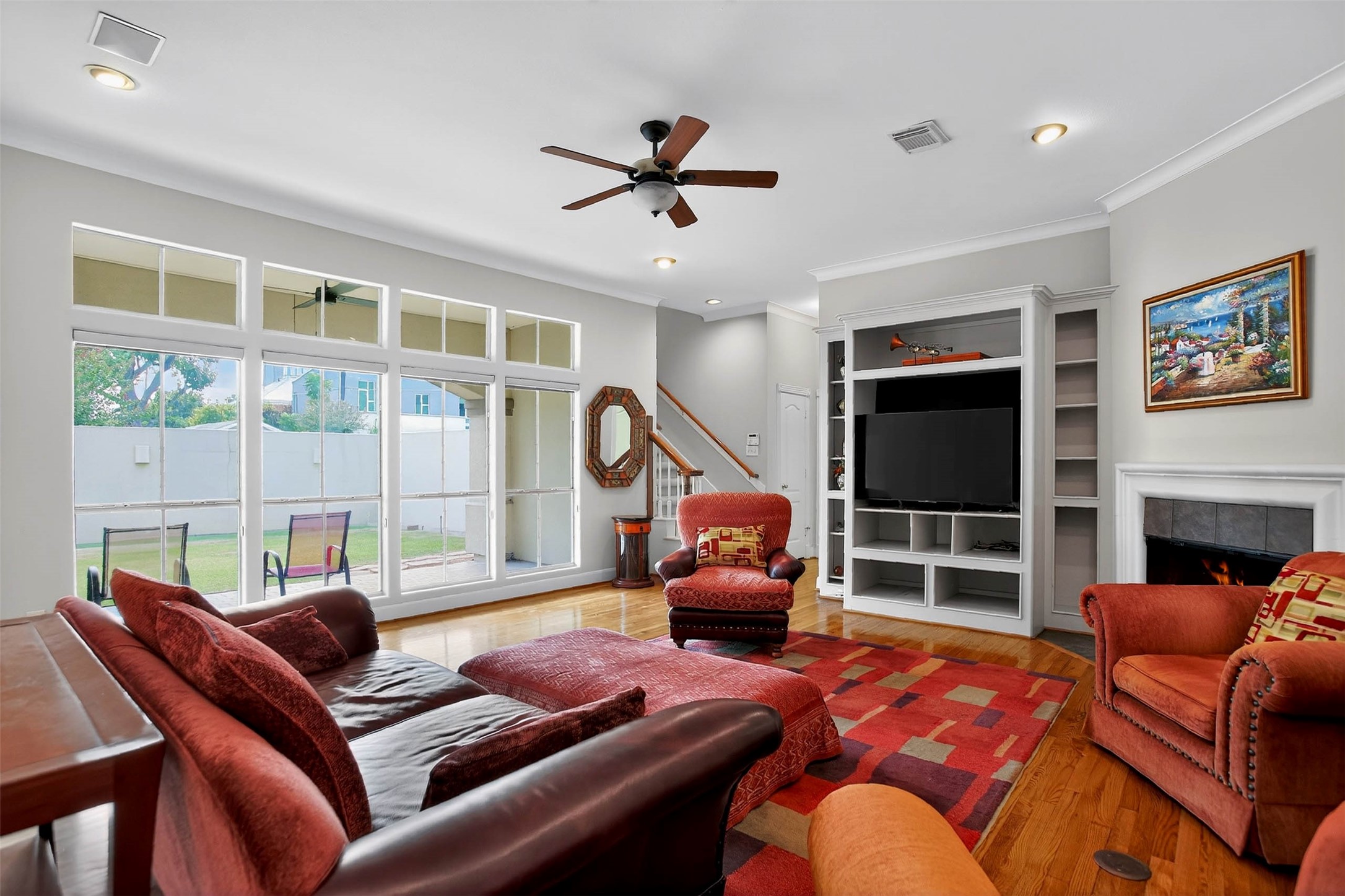 3118 Virginia Street Houston, TX 77098 - Photo 14 of 50 The family room opens up through floor to ceiling glass doors to the outdoor living room featuring a fireplace, perfect for entertaining or enjoying cozy evenings.