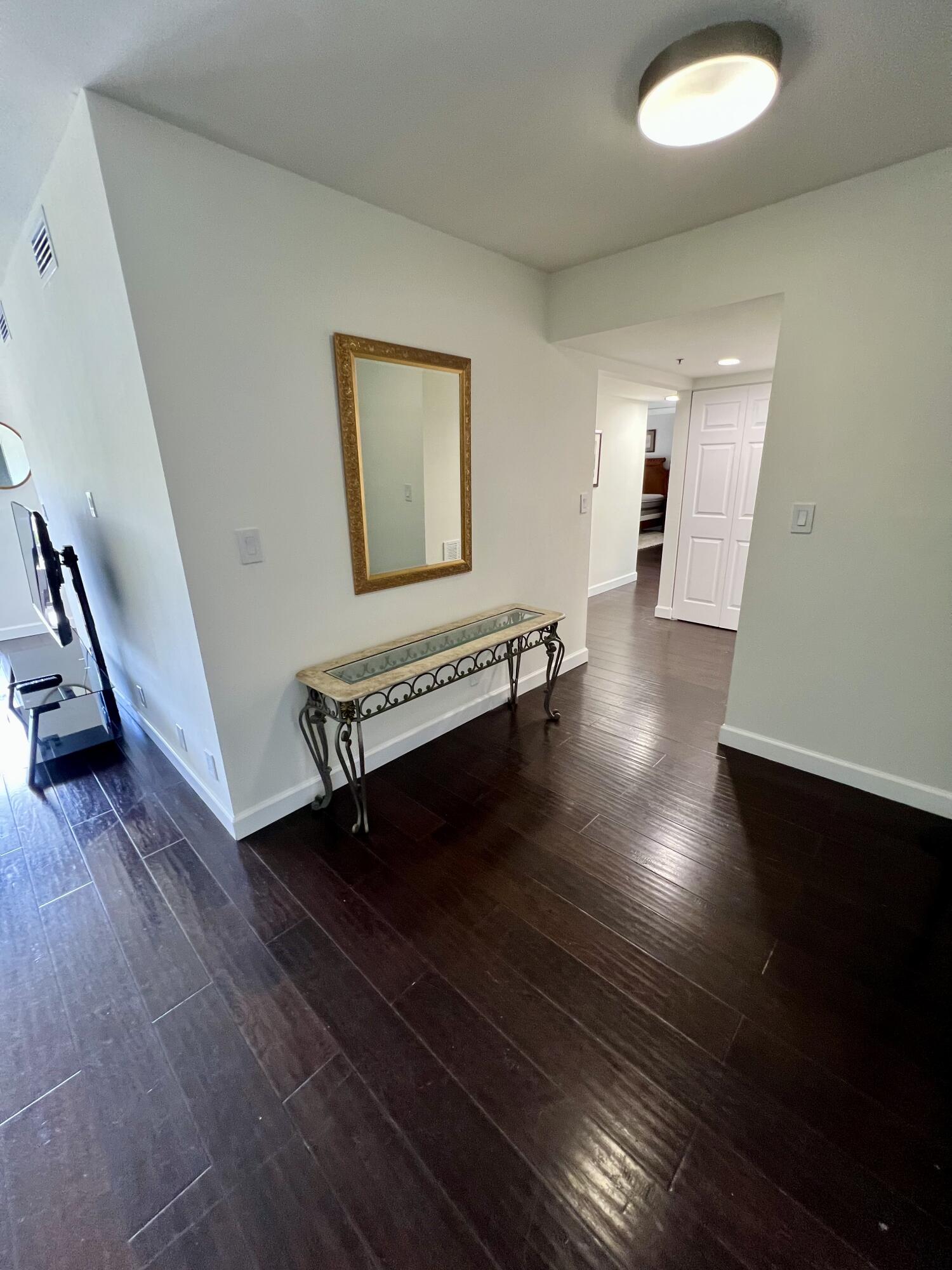23200 Camino Del Mar, Unit 303 Boca Raton, FL 33433 - Photo 5 of 33 a view of an empty room with wooden floor and a window