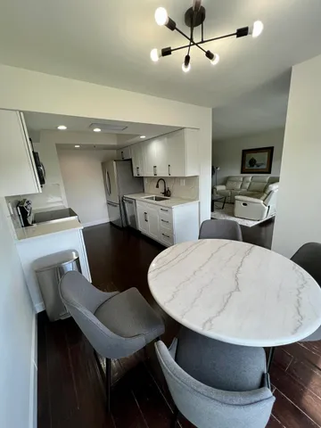 a kitchen with a dining table chairs and white appliances