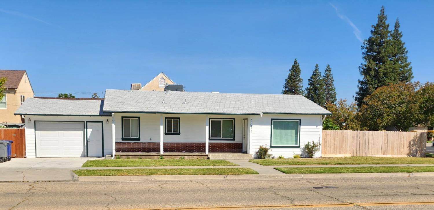 a front view of a house with a garden and trees