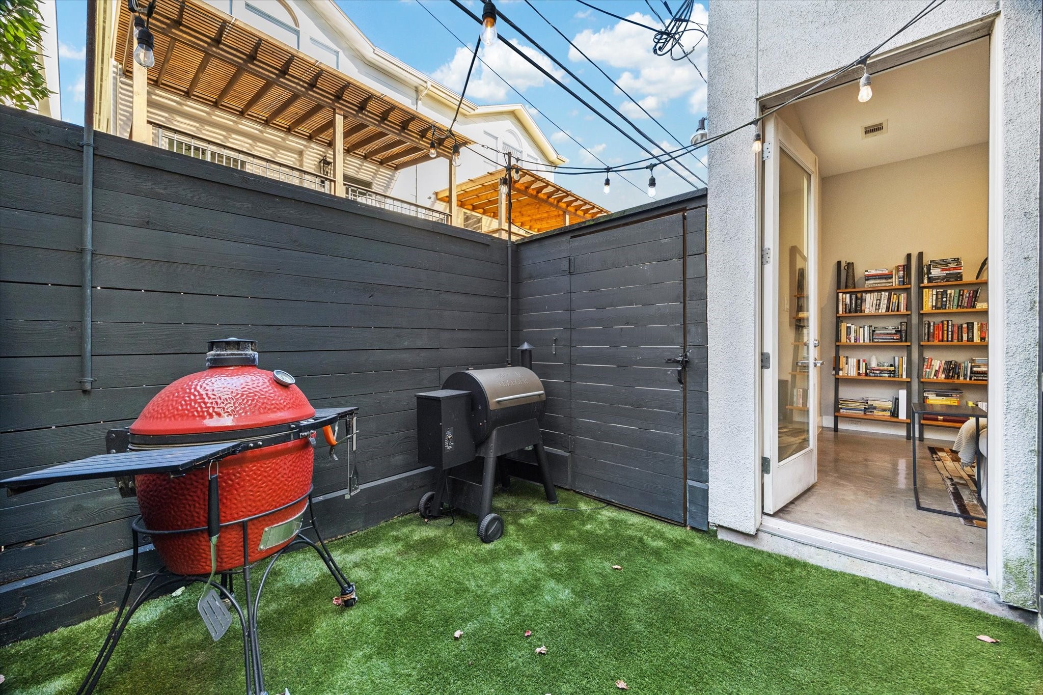 6504 Rodrigo Street, Unit B Houston, TX 77007 - Photo 13 of 29 A private fenced patio with turf and string lights.