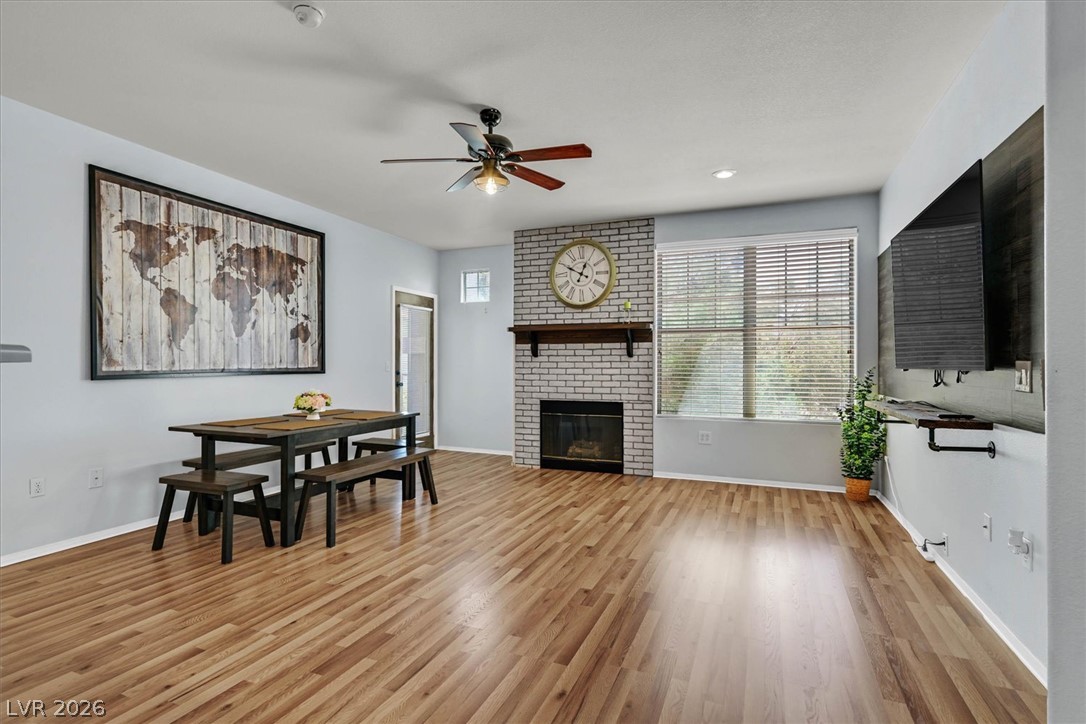 8555 West Russell Road, Unit 2069 Las Vegas, NV 89113 - Photo 12 of 27 Warm wood floors and a whitewashed brick fireplace anchor this welcoming living area, ideal for relaxed gatherings.