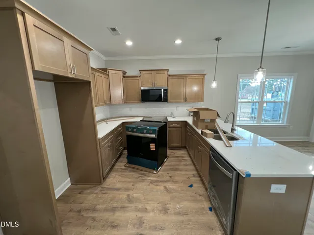 a large kitchen with kitchen island a sink stainless steel appliances and a window