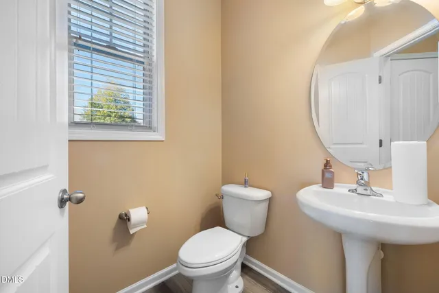 a bathroom with a toilet a sink and a mirror
