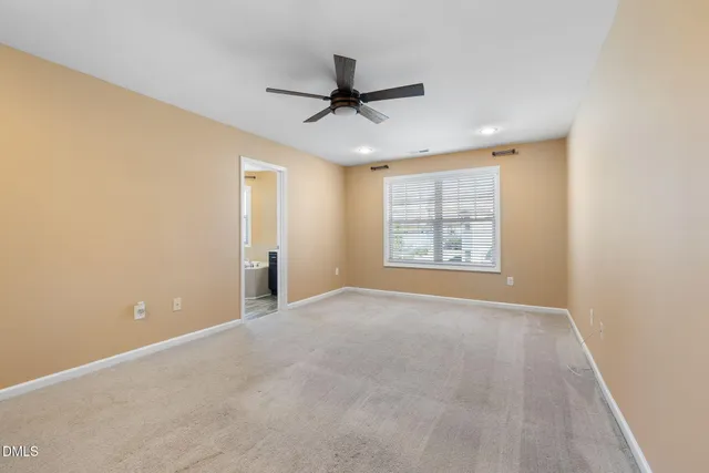 an empty room with windows and ceiling fan
