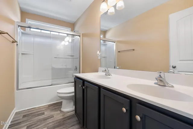 a bathroom with a sink toilet a mirror and shower