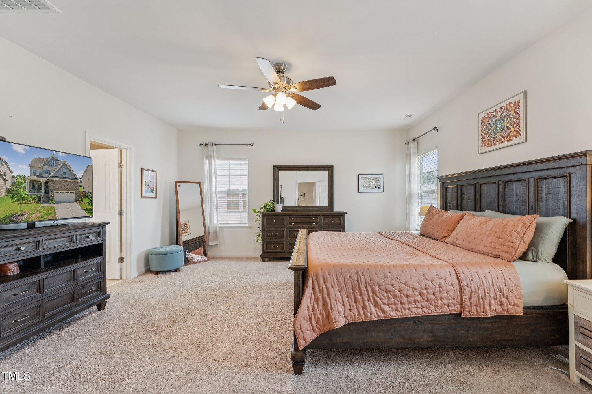 1020 Big Spring Circle Durham, NC 27703 - Photo 17 of 40 a bedroom with a large bed a flat tv screen and a chandelier
