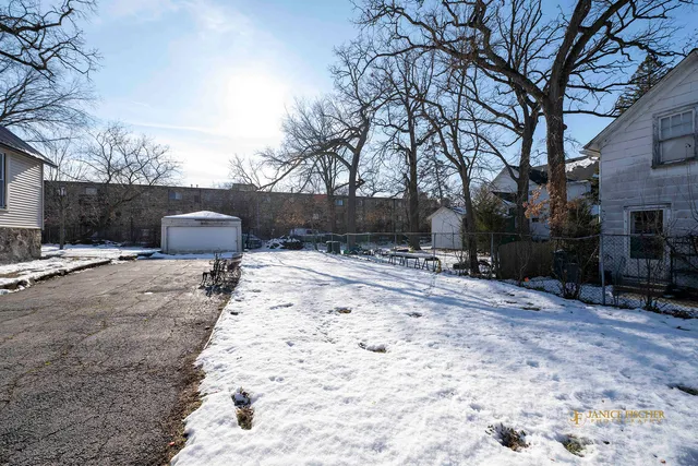 a backyard of a house with fire pit and trees