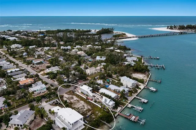 an aerial view of ocean and residential houses with outdoor space